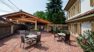 a patio with tables and chairs on a brick patio at Manna Villa in Eger