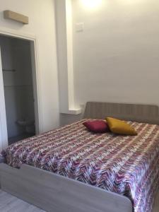 een slaapkamer met een bed met 2 kussens erop bij MARY25 in Montescaglioso
