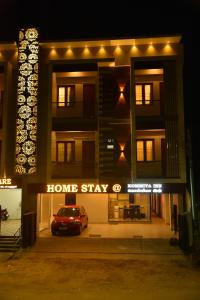 a house with a car parked in front of it at night at Home Stay @ Kommiya Inn in Kumbakonam