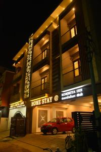 een gebouw waar een auto voor geparkeerd staat bij Home Stay @ Kommiya Inn in Kumbakonam