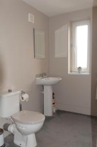 a white bathroom with a toilet and a sink at Stunning View - Jura - Private Members Club in Edinburgh