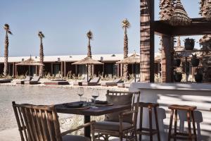 a table with chairs and wine glasses on a patio at Casa Cook North Coast - Adults only in El Alamein