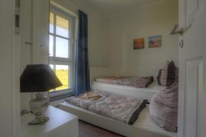 twee bedden in een kamer met een lamp en een raam bij Villa Namenlos in Börgerende-Rethwisch