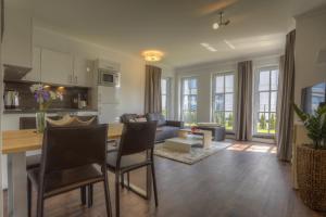 een keuken en woonkamer met een tafel en stoelen bij Villa Namenlos in Börgerende-Rethwisch