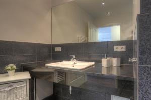 een badkamer met een wastafel en een spiegel bij Villa Namenlos in Börgerende-Rethwisch +48 foto's