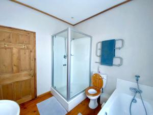 ein Badezimmer mit Dusche, Toilette und Waschbecken in der Unterkunft Melkbos Beach Cottage in Melkbosstrand + 27 Fotos