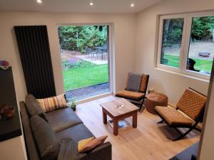 a living room with a couch and chairs and a window at Hogenberg Heiken Lichtaart / Kasterlee in Lichtaart