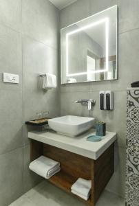 a bathroom with a sink and a mirror at The Avatar Hotel & Convention in Mangalore