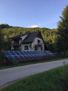 ein Haus mit Sonnenkollektoren vor einem Haus in der Unterkunft Agropensjonat Tramp z góralskim spa in Żabnica