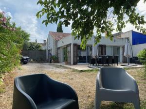 ラ・シオタにあるClos Des Plages Maison De Vacancesの庭に黒い椅子が2脚ある家