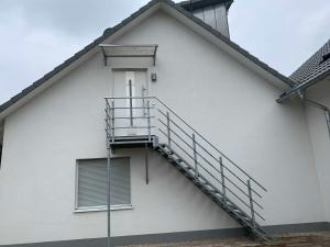 un escalier sur le côté d'un bâtiment blanc dans l'établissement Ferienwohnung Warthmann, à Schwanau