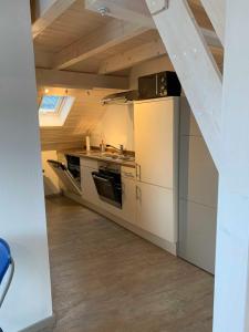 Il comprend une cuisine avec des placards blancs et un plafond voûté. dans l'établissement Ferienwohnung Warthmann, à Schwanau