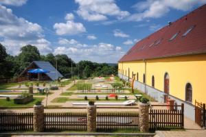 un edificio amarillo con techo rojo y parque infantil en Hotel Restaurant Na Statku, en Náměšť nad Oslavou