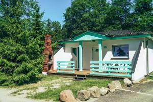 Casa blanca pequeña con porche y chimenea de ladrillo en Lake Park Łagów, en Łagów