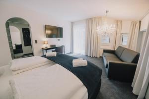 sypialnia z dużym łóżkiem i kanapą w obiekcie The Place Boutique & Design Hotel Flachau w mieście Flachau