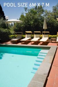 a swimming pool with lounge chairs and an umbrella at FH55 Hotel Villa Fiesole in Fiesole