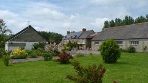 un grupo de casas en un patio con césped verde en chambres d'hôtes proche saint Malo et mont saint Michel, en La Boussac