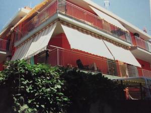 Edificio rojo y blanco con balcón en Casa Vacanza Mauricio, en Falcone