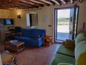Pinos PuenteにあるCasa Rural Huerta Sarténのリビングルーム(青いソファ、ガラスの引き戸付)