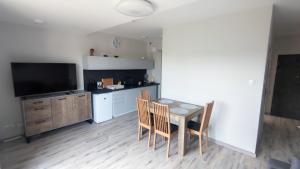 a kitchen with a table and chairs and a television at Źródełko Rac in Świeradów-Zdrój