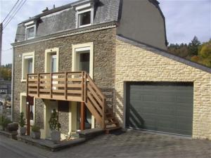 ceglany dom z garażem i drewnianym tarasem w obiekcie Le Valhento w mieście Bouillon