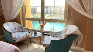 a bedroom with two chairs and a table and a window at B-LBAIT KAEC Honeymoon Style for family in King Abdullah Economic City