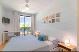 Un dormitorio blanco con una cama grande y una ventana. en New home on the beach, en Colonia de Sant Jordi