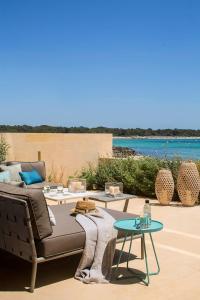 un patio con sofá y mesa en New home on the beach, en Colonia de Sant Jordi
