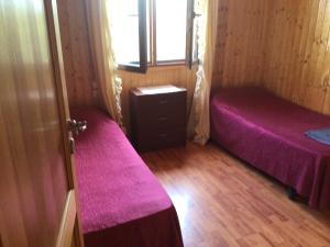 Habitación pequeña con 2 camas y ventana en casa peninsula caspe 1, en Caspe