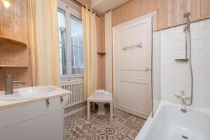 ein Bad mit einer Badewanne, einem Waschbecken und einer Dusche in der Unterkunft Appartement Coeur de Ville rue Saint-Laud in Angers