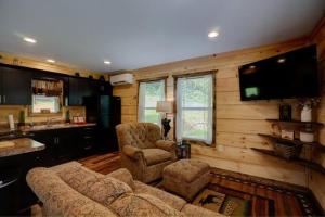 a living room with a couch and a tv in a house at Dragon's Nest Cabin with Mountain Views in Robbinsville