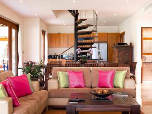 a living room with a couch with pink and green pillows at Tawantok Beach Villas - SHA Extra Plus in Lipa Noi