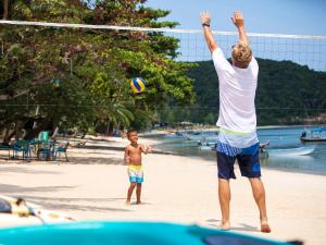 un uomo e un ragazzo che giocano a pallavolo sulla spiaggia di Tawantok Beach Villas - SHA Extra Plus a Lipa Noi