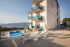 a building with a swimming pool next to a resort at Apartments BlueView in Postira