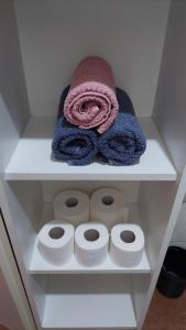 ein weißes Regal mit Handtüchern und Rollen Toilettenpapier in der Unterkunft Apartment Oaza in Rogoznica + 30 Fotos
