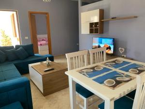 un soggiorno con tavolo e divano blu di Guest House Tian a Durrës