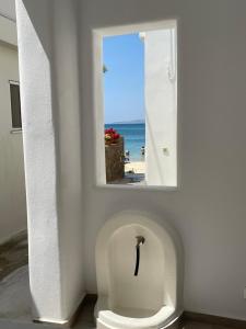 a bathroom with a urinal with a picture of the beach at Theofanis Studios in Agia Anna Naxos