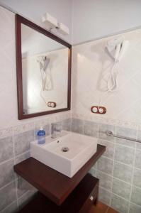 La salle de bains est pourvue d'un lavabo blanc et d'un miroir. dans l'établissement Apartamentos Turisticos Sanahuja, à Valbona