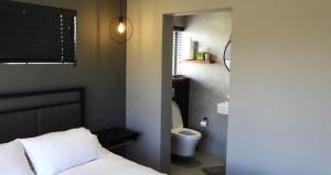 a bedroom with a bed and a bathroom with a toilet at Comfort in Langebaan in Langebaan