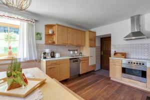 EmbachにあるFerienhaus Auwieseの木製キャビネットとテーブル付きの広いキッチンが備わります。