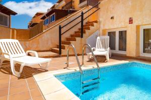 a patio with two chairs and a swimming pool at Casa Dorada in La Oliva