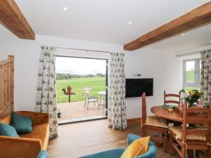 a living room with a television and a table and chairs at Shires Rest in Sturminster Newton