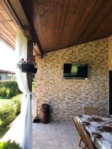 un patio con mesa y TV en una pared de ladrillo en Къща за гости, Guesthouse GOTINOTO, en Krapets