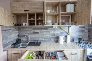 - une cuisine avec des placards en bois et un évier dans l'établissement Center Home Apartman, à Orosháza