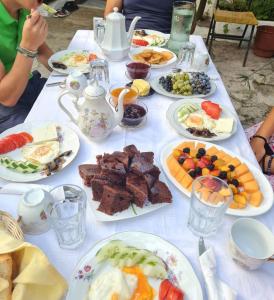 ein weißer Tisch mit Teller mit Lebensmitteln drauf in der Unterkunft Vrenjo GuestHouse in Gjirokastër
