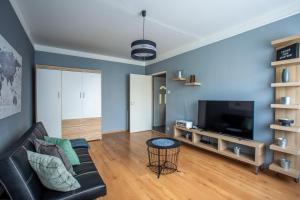 Center Home Apartman في أورشازا: غرفة معيشة مع أريكة وتلفزيون بشاشة مسطحة