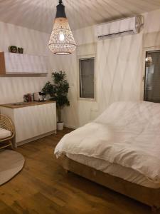 1 dormitorio con cama y lámpara de araña en חדר במדבר, en Beʼer Ora