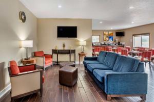 uma sala de estar com um sofá azul e cadeiras vermelhas em Comfort Inn Muscatine near Hwy 61 em Muscatine