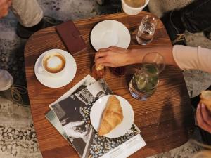 una mesa de madera con platos de comida y una taza de café en ibis Frankfurt Centrum, en Frankfurt