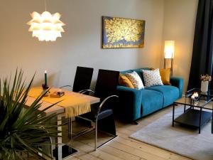 a living room with a blue couch and a table at Schöne Ferienwohnung am Mathildenbrunnen in Quedlinburg